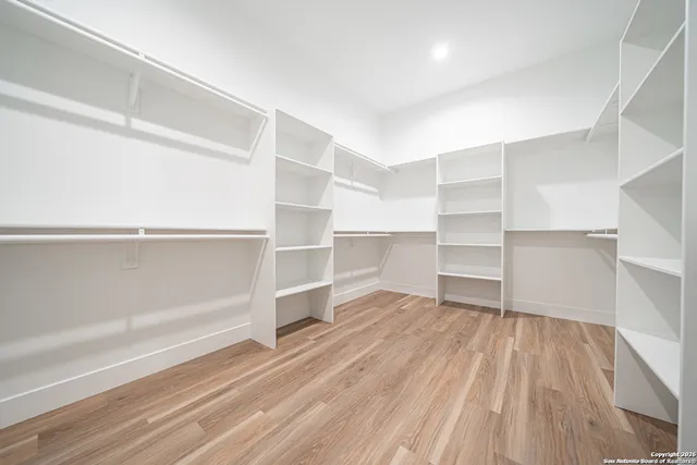 a view of walk in closet with empty racks