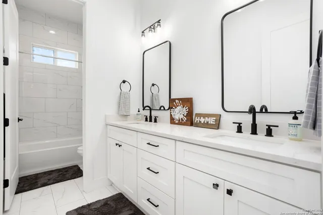 a bathroom with a double vanity sink a mirror and a bathtub