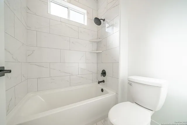 a white bath tub sitting next to a white toilet