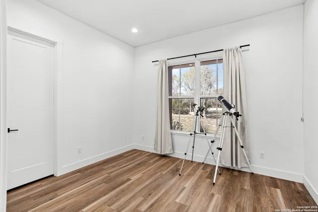 an empty room with wooden floor and mirror