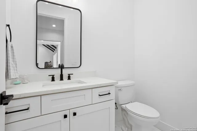 a bathroom with a toilet sink and mirror