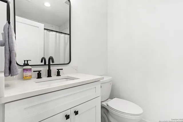 a bathroom with a toilet sink and mirror