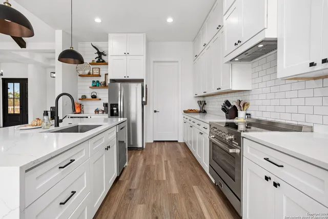 a kitchen with kitchen island a sink stainless steel appliances and cabinets