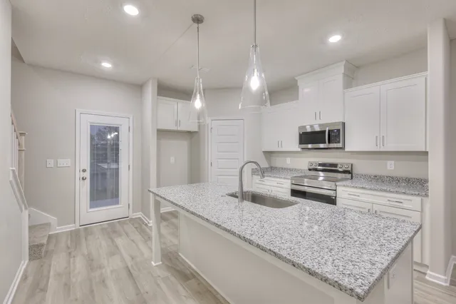 a kitchen with stainless steel appliances granite countertop a sink refrigerator and microwave