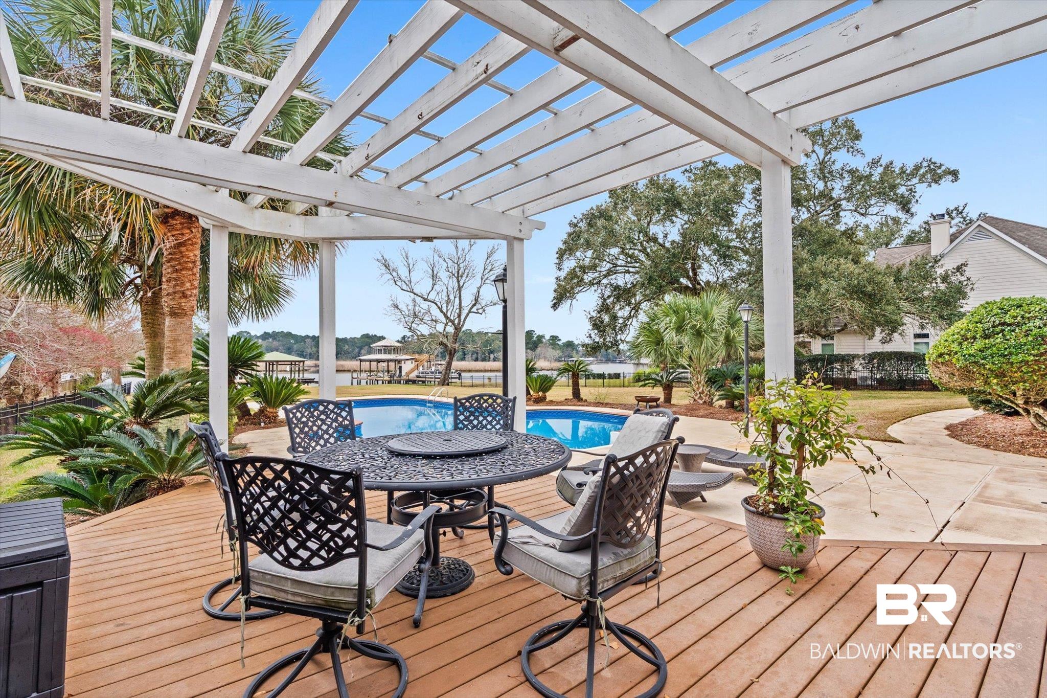 4851 Audubon Drive Mobile, AL 36619 - Photo 25 of 46 Wooden terrace featuring an outdoor pool, outdoor dining space, a pergola, and a patio