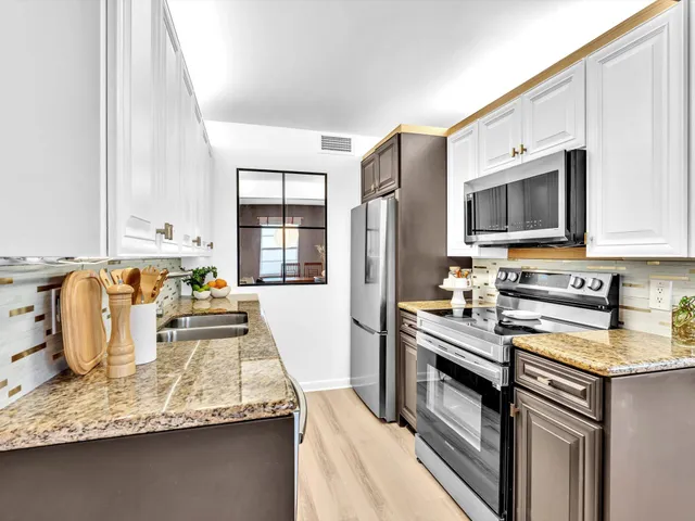 a kitchen with stainless steel appliances granite countertop a sink stove and refrigerator