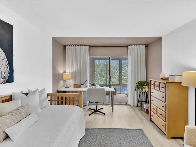 a bedroom with a bed and a lamp on the dresser