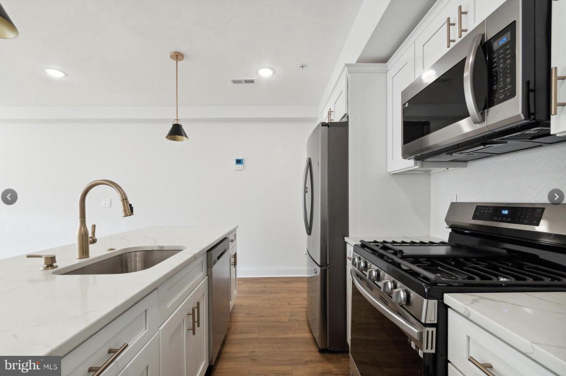 673 North Preston Street, Unit 4 Philadelphia, PA 19104 - Photo 4 of 9 a kitchen with stainless steel appliances granite countertop a sink stove and microwave