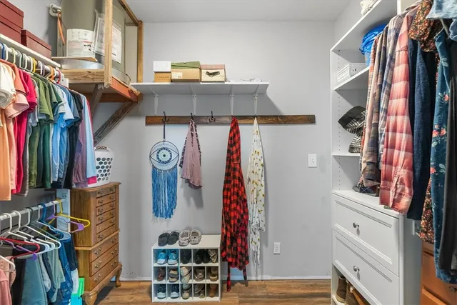 a view of walk in closet with clothes and shoes