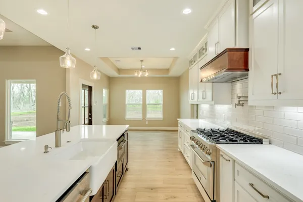 a kitchen with stainless steel appliances a sink stove and cabinets