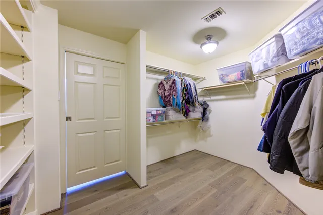 a view of walk in closet with clothes and shoes