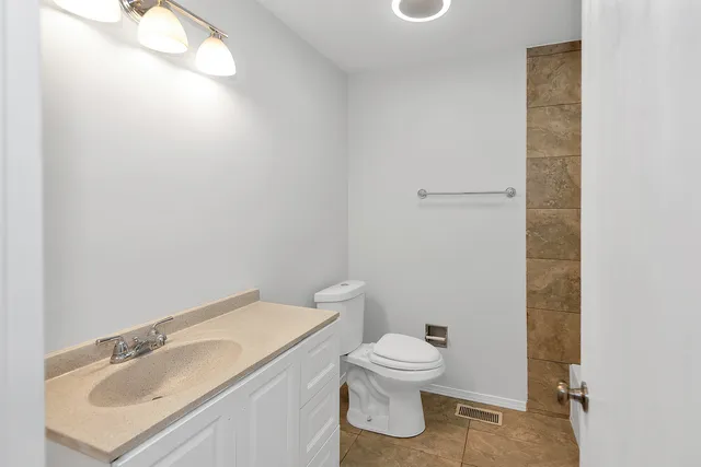 a white toilet sitting next to a bathroom sink