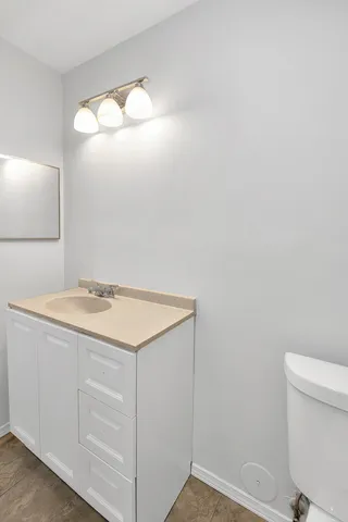 a bathroom with a sink vanity and a toilet