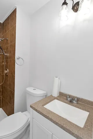 a bathroom with a granite countertop toilet and a sink