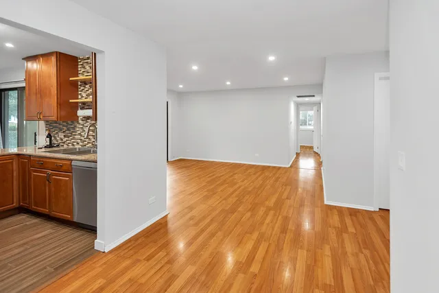 a view of a room with wooden floor and furniture