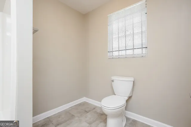 a white toilet sitting next to a white cabinet