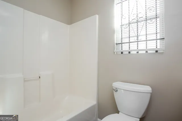 a bathroom with a toilet and a window