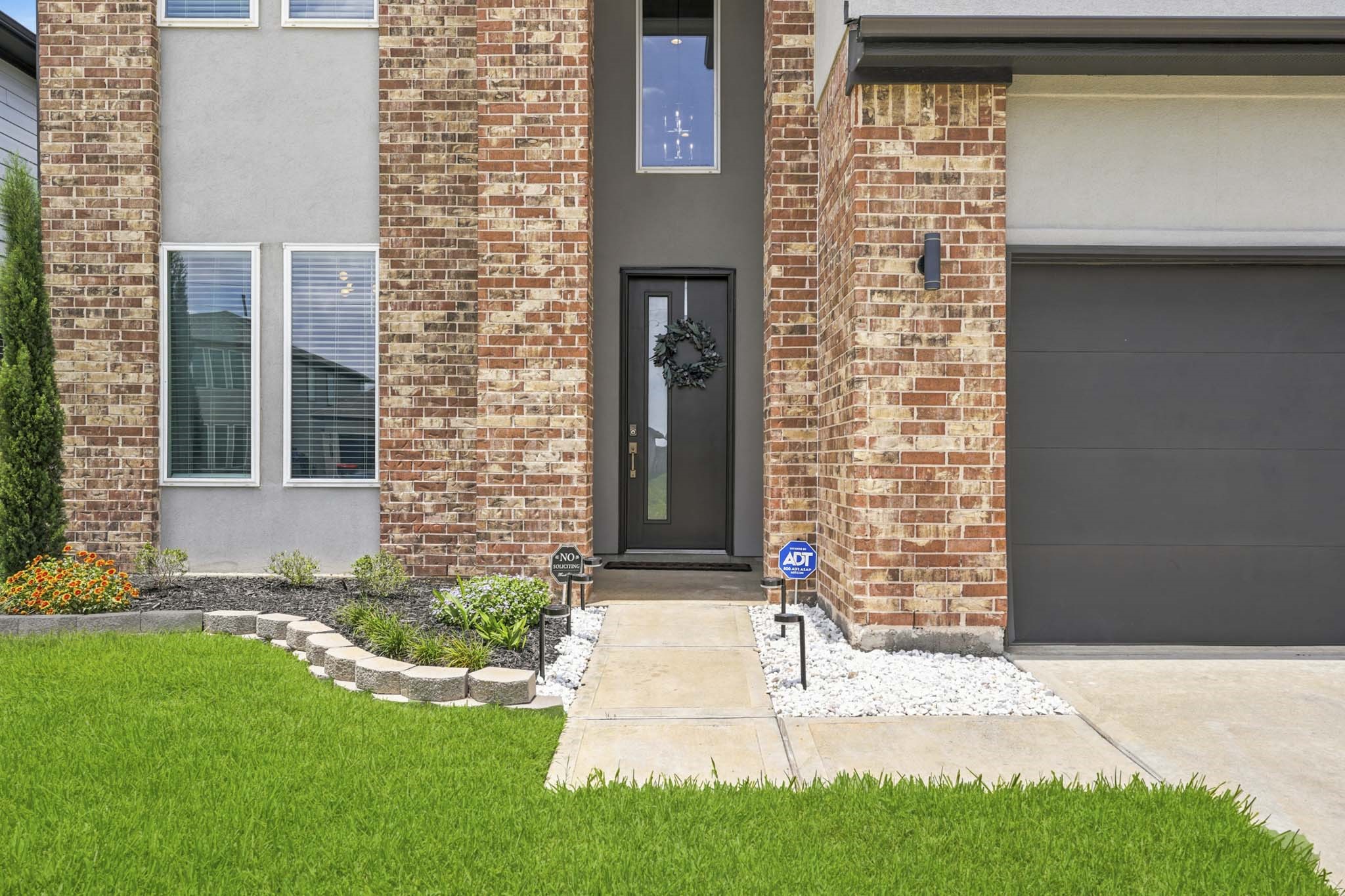 22522 Modica Rift Lane Katy, TX 77449 - Photo 7 of 38 First impressions don't get much better than this. The dramatic full-height entry tower frames a sleek dark front door adorned with a welcoming wreath, flanked by lush plantings, white river rock beds, and blooming color. This entry doesn't just welcome you home — it makes you feel like you've arrived somewhere truly special.