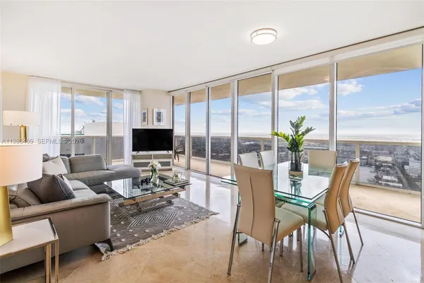 a living room with furniture a flat screen tv and a large window