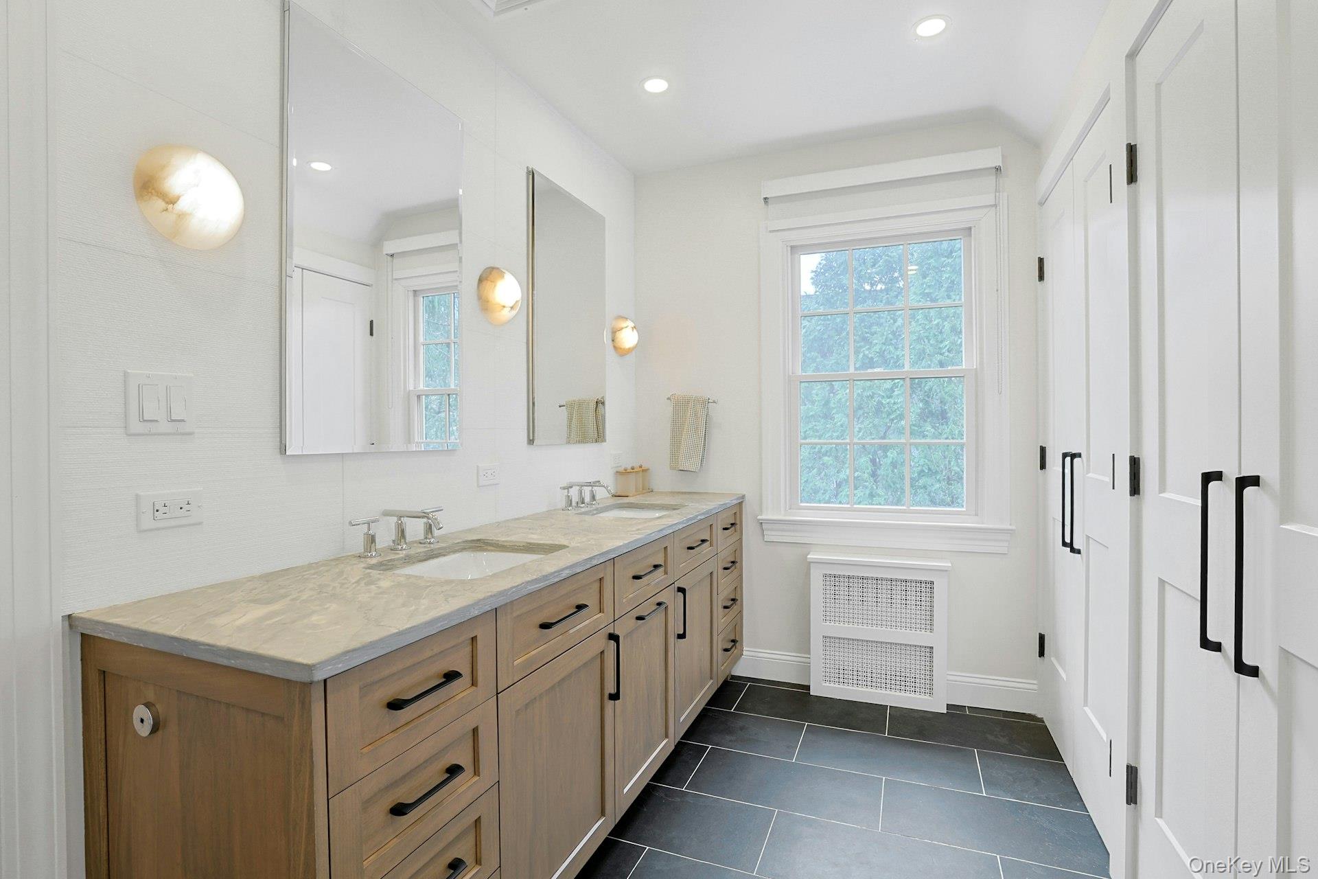 21 Tisdale Road Scarsdale, NY 10583 - Photo 19 of 40 Sophisticated primary ensuite bath with double vanity, marble countertops, glass-enclosed shower (pictured next), radiant heated floors, and an abundance of closet space.