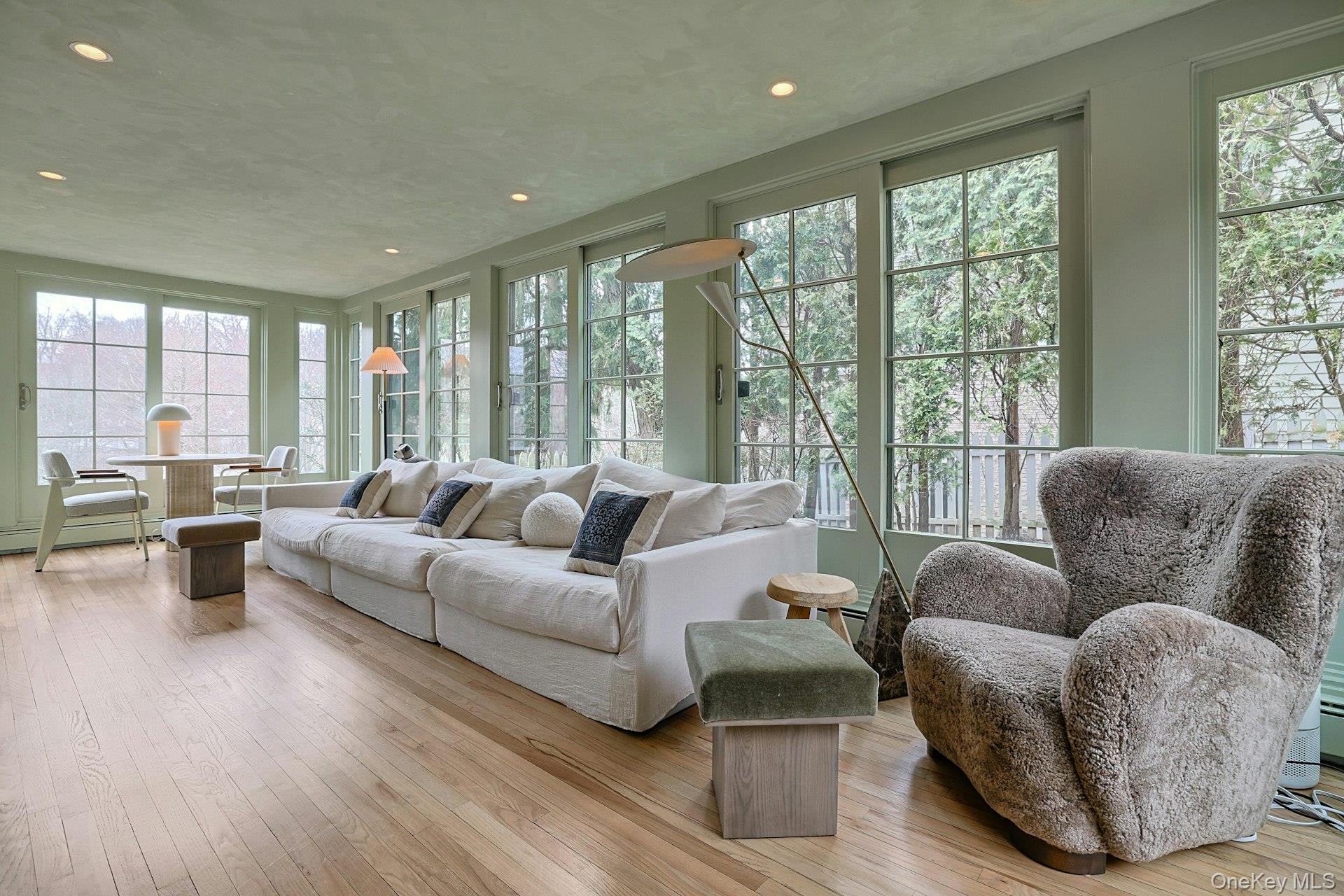 21 Tisdale Road Scarsdale, NY 10583 - Photo 7 of 40 Bathed in natural light, this sunroom features walls of windows with endless views of Crane Berkley pond. Sliding doors access the front and backyards.