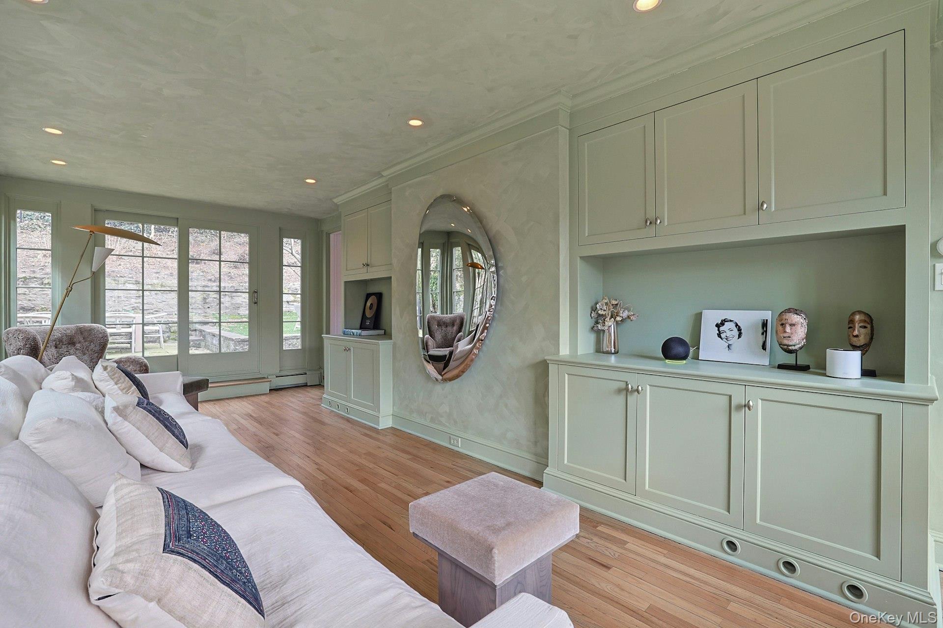 21 Tisdale Road Scarsdale, NY 10583 - Photo 8 of 40 Custom built-ins add both function and style, offering a beautifully tailored backdrop within the sunroom. Sliding doors offer access to the back patio.