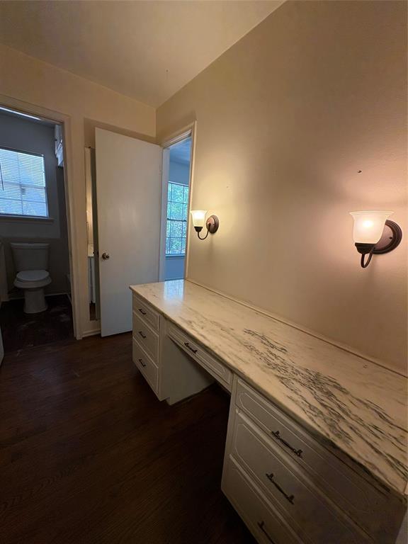 5454 Ranchero Lane Dallas, TX 75236 - Photo 19 of 24 Built-in vanity with a stone countertop, sconce lighting, and wood-finish flooring