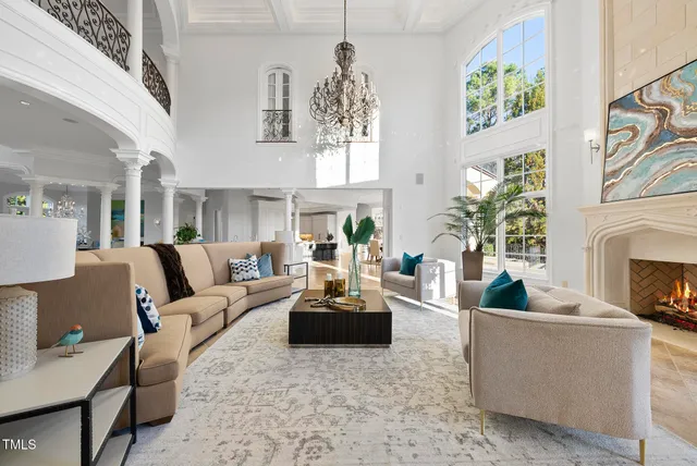 a living room with furniture a fireplace and chandelier
