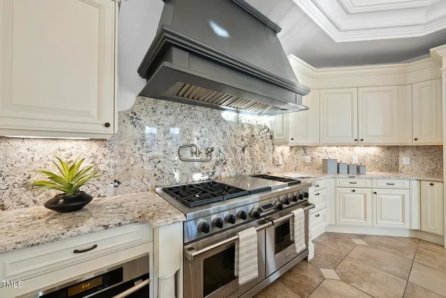 a kitchen with stainless steel appliances kitchen island granite countertop a table chairs sink and cabinets