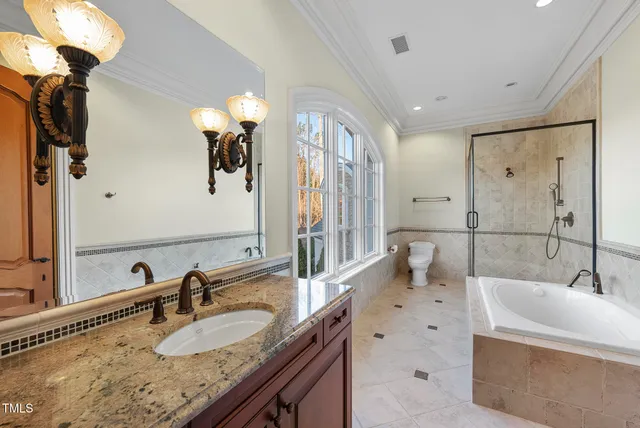 a spacious bathroom with a granite countertop tub a double vanity sink a vanity and a large mirror