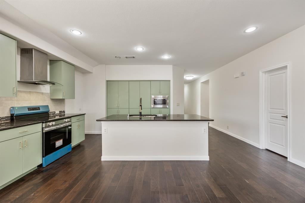 4104 Gaillardia Way Forney, TX 75126 - Photo 11 of 34 a large kitchen with stainless steel appliances granite countertop a lot of counter space and wooden floor