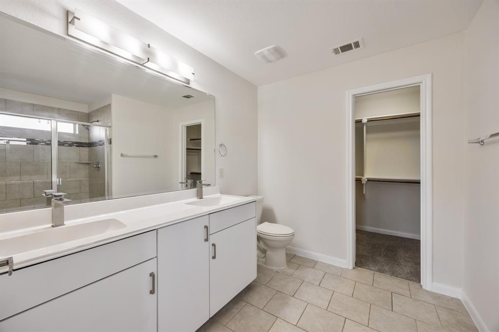 4104 Gaillardia Way Forney, TX 75126 - Photo 26 of 34 a bathroom with a sink a toilet and a mirror