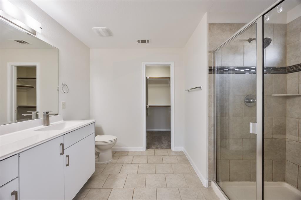 4104 Gaillardia Way Forney, TX 75126 - Photo 27 of 34 a bathroom with a double vanity sink toilet and shower