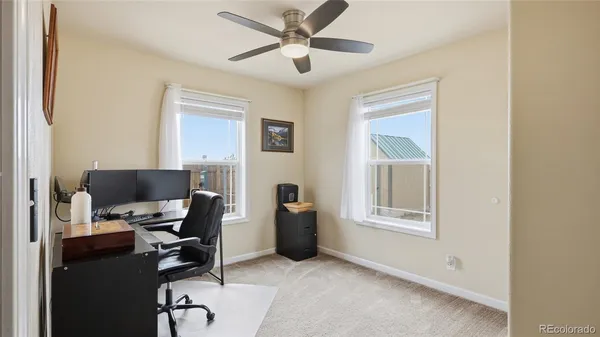 a view of a workspace with furniture and a window