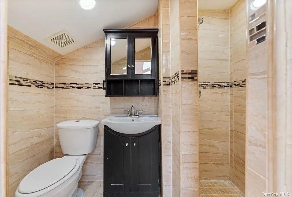 a bathroom with a toilet sink shower and mirror