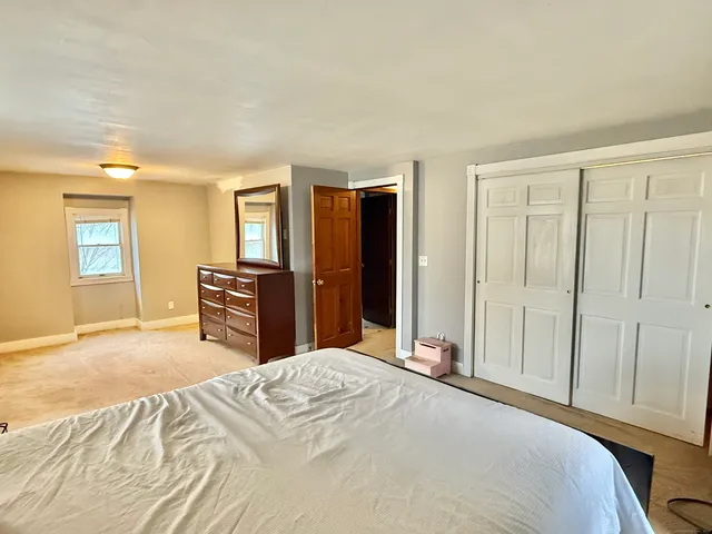 a bedroom with a large bed and a chandelier