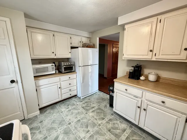 a kitchen with white cabinets and white appliances