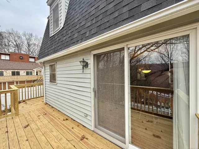 a view of a porch with wooden floor and floor to ceiling window