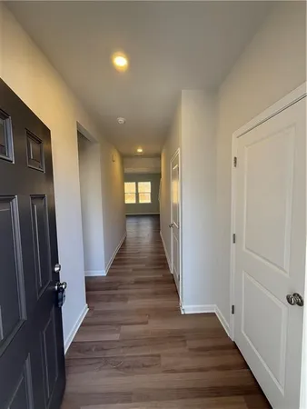 a view of a hallway with wooden floor and staircase