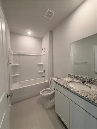 a bathroom with a granite countertop sink a toilet and bathtub