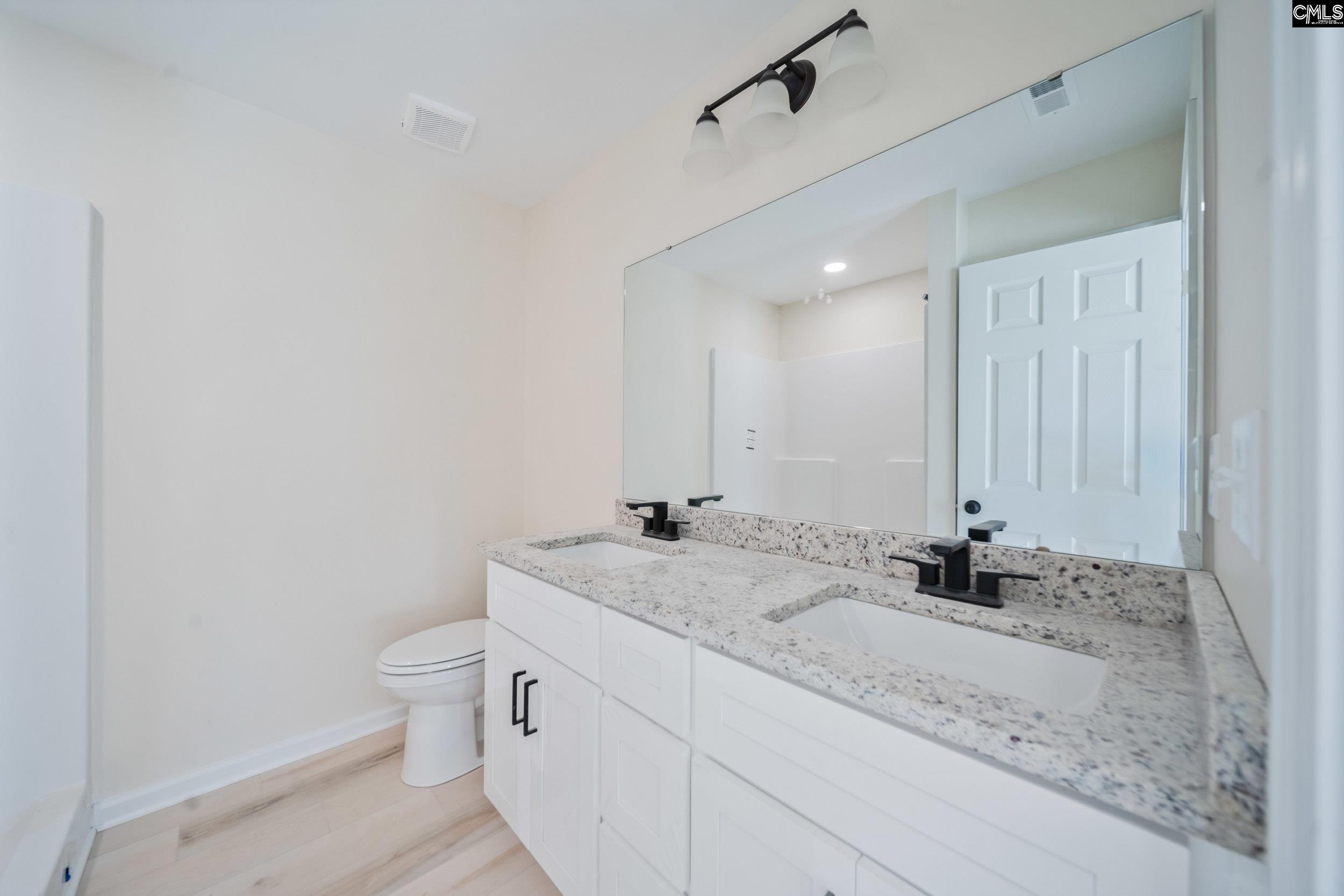 116 Sunny Acres Road Eastover, SC 29044 - Photo 24 of 40 a bathroom with a granite countertop sink mirror vanity and toilet