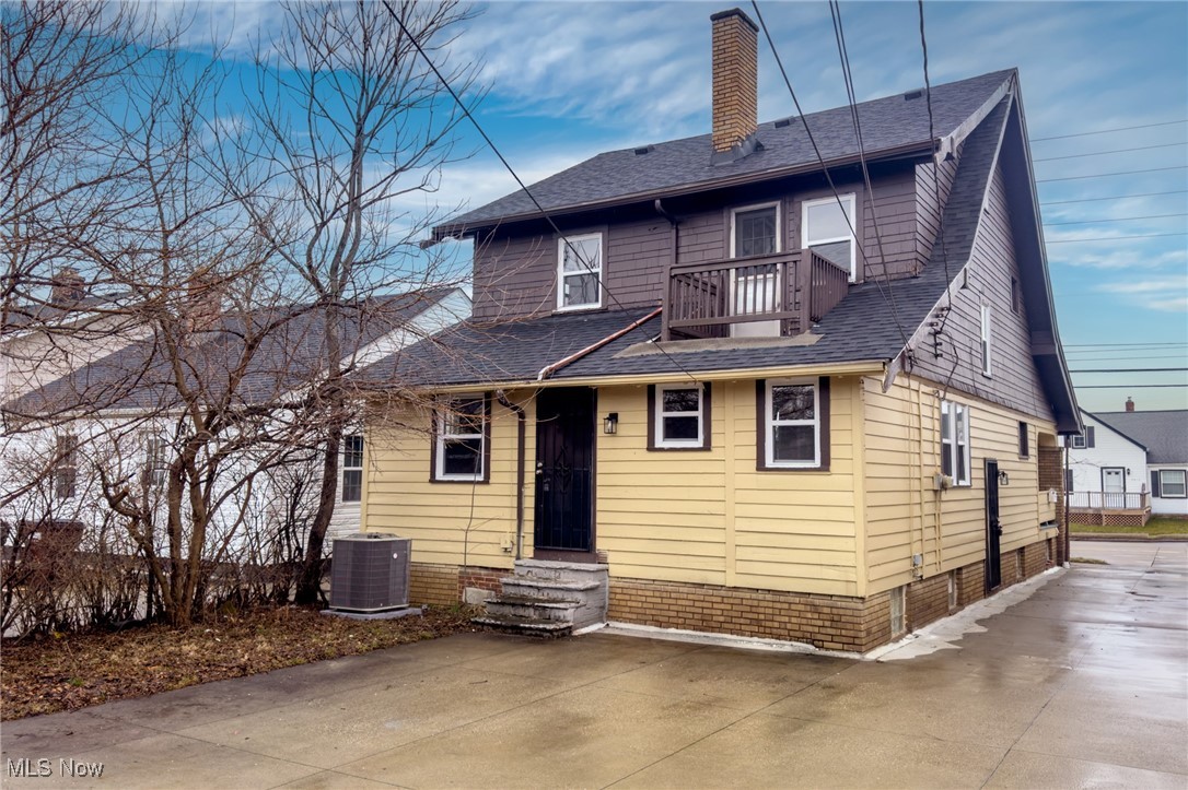 7911 Snow Road Parma, OH 44129 - Photo 41 of 44 View of front facade featuring a balcony, entry steps, a shingled roof, and a chimney