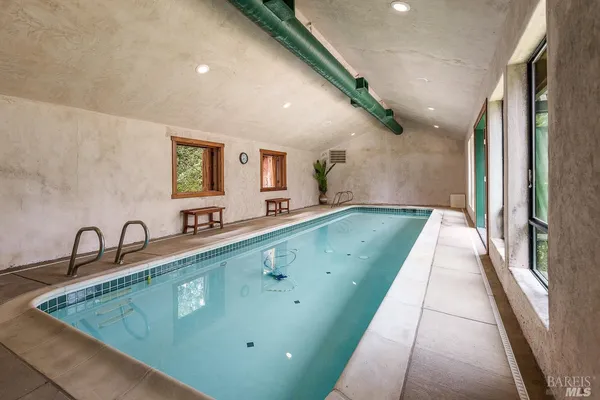 a room with pool table and large windows