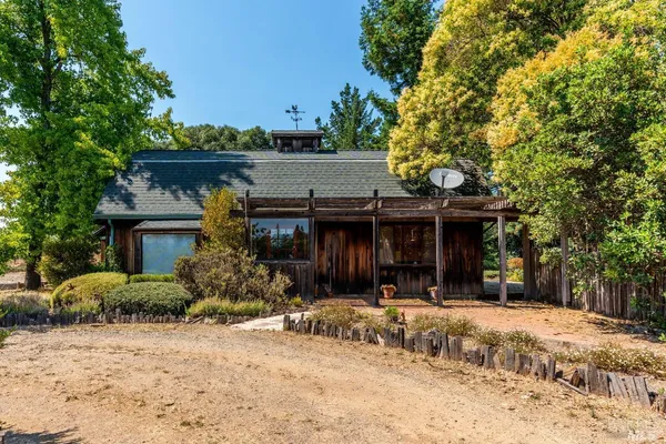 a view of a house with a tree in front of it