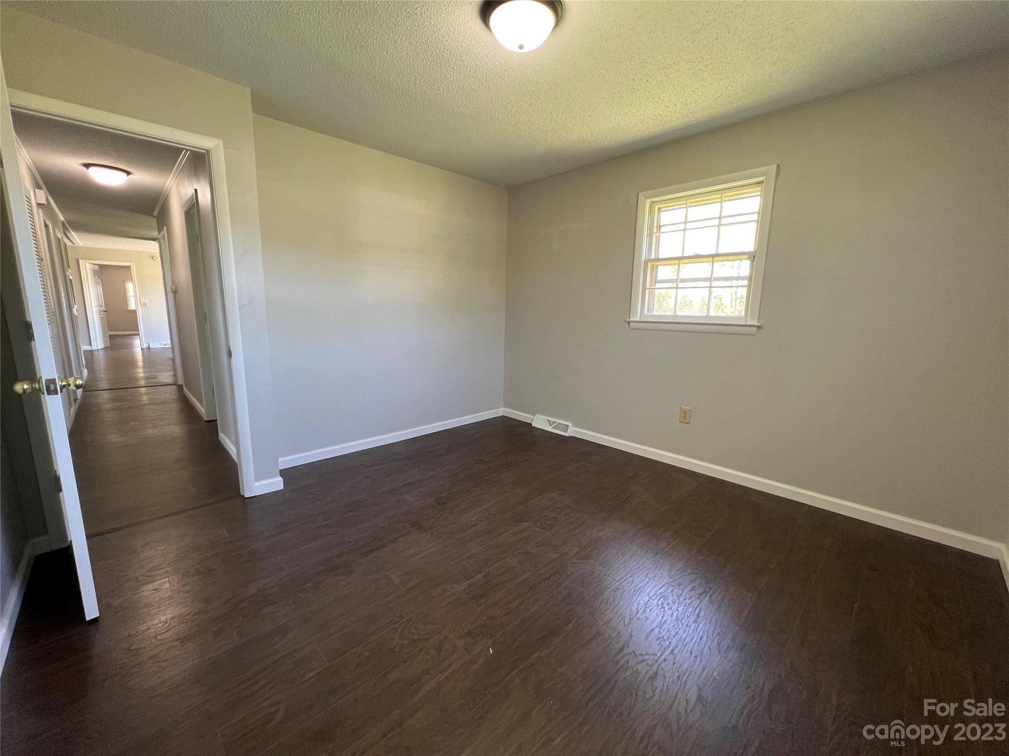 590 Hog Pen Branch Road Mooresboro, NC 28114 - Photo 21 of 36 an empty room with wooden floor and windows