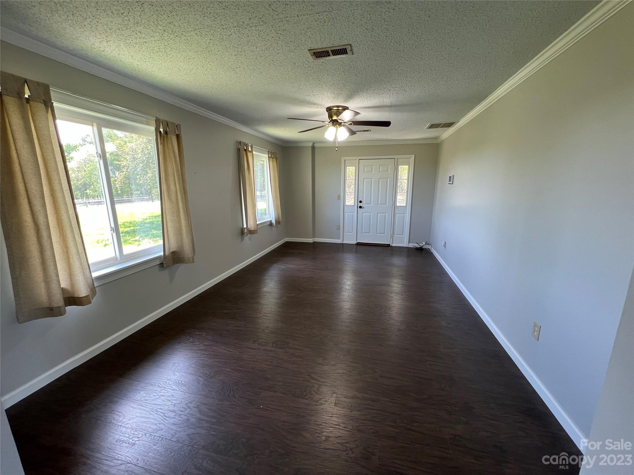 590 Hog Pen Branch Road Mooresboro, NC 28114 - Photo 6 of 36 an empty room with wooden floor and windows