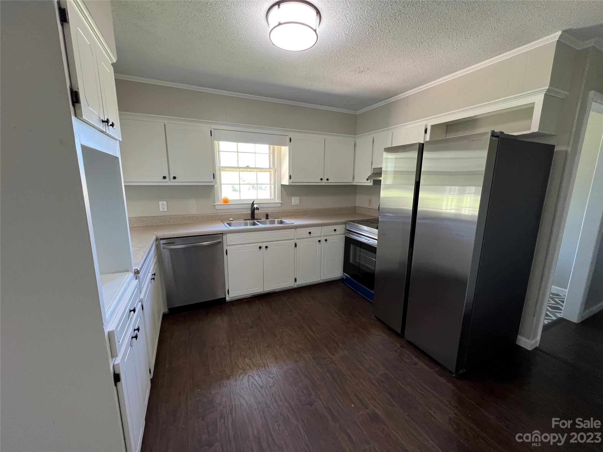 590 Hog Pen Branch Road Mooresboro, NC 28114 - Photo 9 of 36 a kitchen with stainless steel appliances a refrigerator a sink a stove a refrigerator and cabinets
