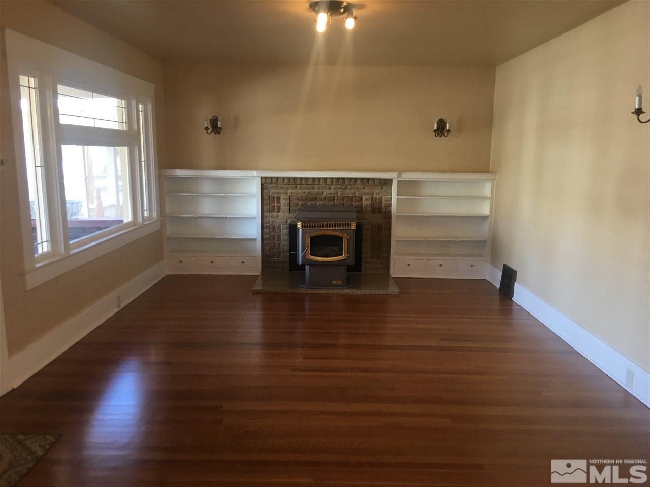 911 F Street Sparks, NV 89431 - Photo 2 of 15 an empty room with wooden floor fireplace and windows