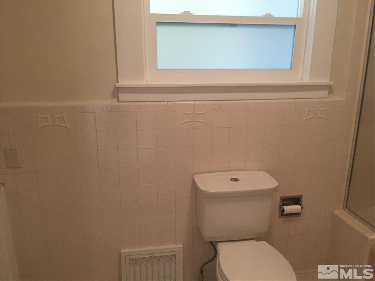 911 F Street Sparks, NV 89431 - Photo 9 of 15 a white toilet sitting next to a white sink and vanity