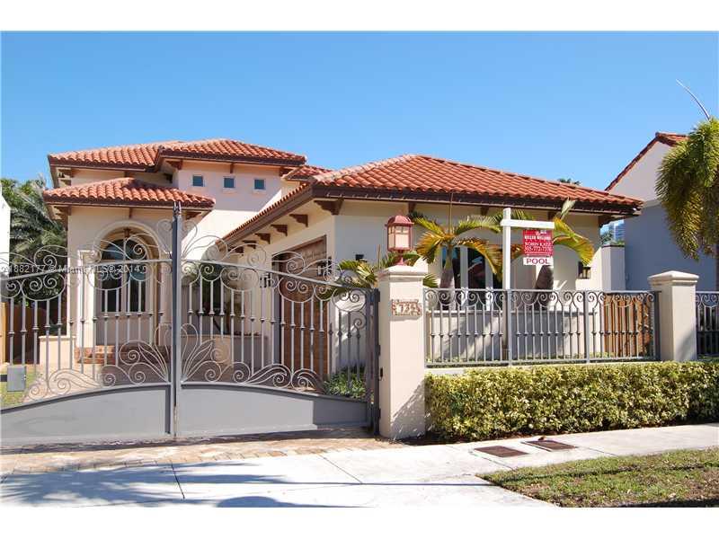 a view of a white house with large windows and a small yard